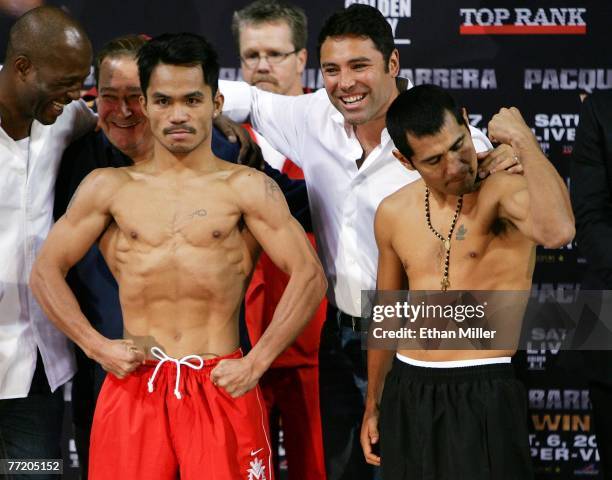 Boxers Manny Pacquiao of Philippines and Marco Antonio Barrera of Mexico pose as Oscar De La Hoya looks on during their official weigh-in at the...