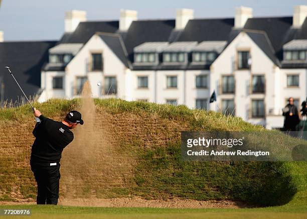 Soren Hansen of Denmark plays from a bunker on the 16th hole in front of the hotel during the third round of The Alfred Dunhill Links Championship at...