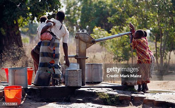 Children pump water outside of the Ligwangwa village October 3, 2007 in Ligwangwa, Malawi. In an effort to spread hope, education, love and...