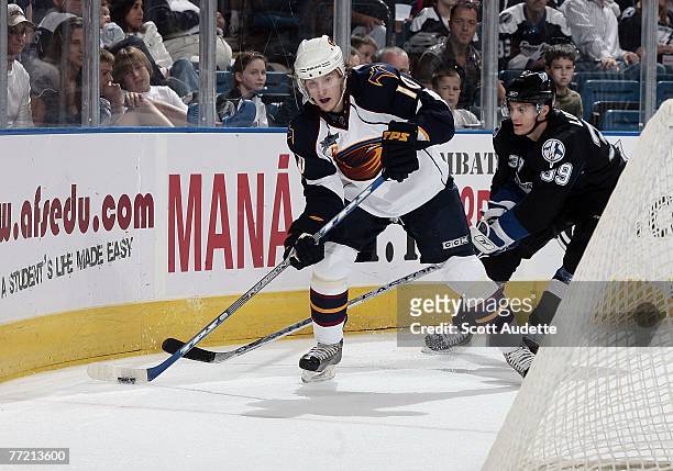 Mike Lundin of the Tampa Bay Lightning puts pressure on Bryan Little of the Atlanta Thrashers as he skates behind the net at St. Pete Times Forum on...