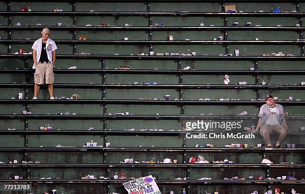Two fans of the Chicago Cubs remain in the bleachers as they look dejected after the Cubs lost 5-1 against the Arizona Diamondbacks during Game Three...
