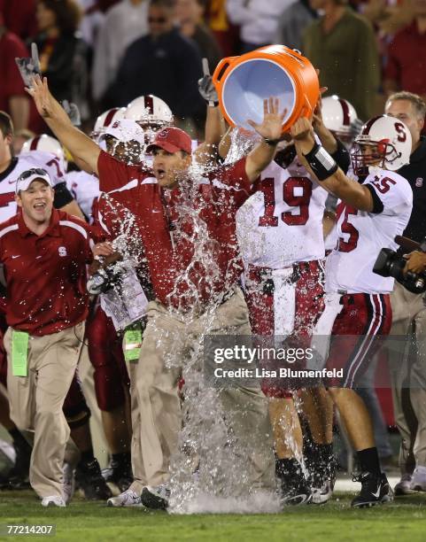 Alex Loukas celebrates with head coach Jim Harbaugh of the Stanford University Cardinal after defeating the USC Trojans 24-23 at the Los Angeles...