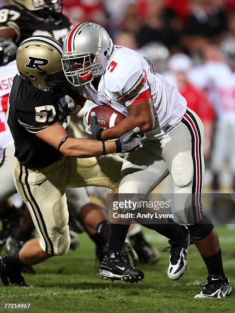 Brandon Saine of the Ohio State Buckeyes runs with the ball while defended by Tyler Haston the Purdue Boilermakers during the game on October 6, 2007...