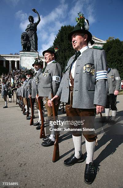 Traditionally dressed Bavarian riflemen wait with their guns in front of the giant bronze figure Bavaria during the last day of Oktoberfest beer...