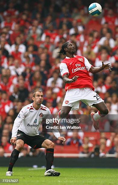 Danny Higginbotham of Sunderland tries to tackle Emmanuel Adebayor of Arsenal during the Barclays Premier League match between Arsenal and Sunderland...