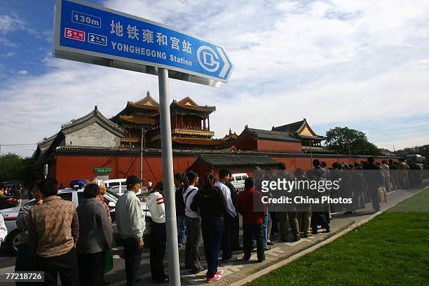 Commuters queue to buy souvenir ticket at the Yonghegong Lama Temple station of the newly-opened No. 5 subway line on October 7, 2007 in Beijing,...