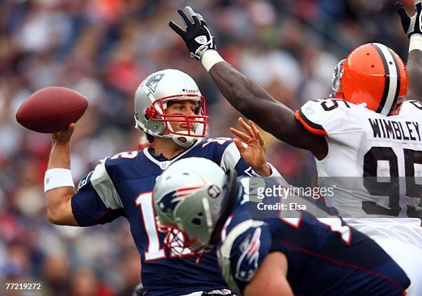Tom Brady of the New England Patriots passes the ball under pressure from Kamerion Wimbley of the Cleveland Browns defends on October 7, 2007 at...