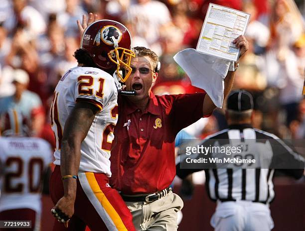 Washington Redskins Assistant Head Coach for Defense, Gregg Williams, congratulates safety Sean Taylor after Taylor delivered a key block on a punt...