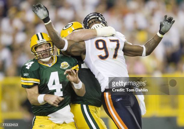 Quarterback Brett Favre of the Green Bay Packers watches his pass as Mark Anderson of the Chicago Bears is held off at an NFL game against the...