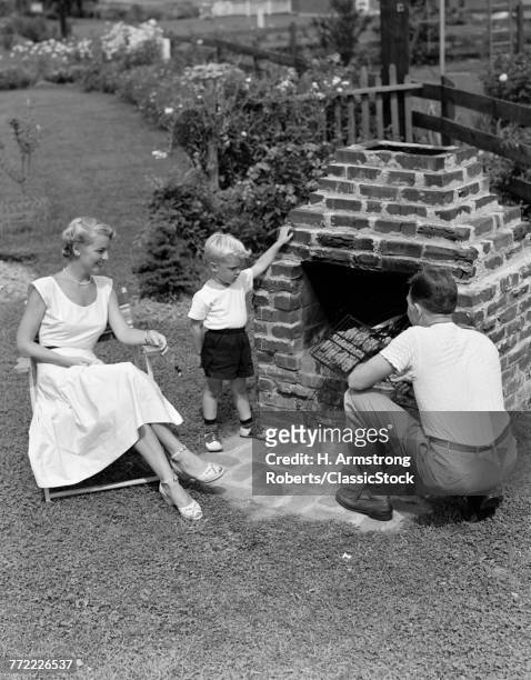 1940s 1950s FAMILY IN BACKYARD COOKING HAMBURGERS ON BRICK BARBECUE