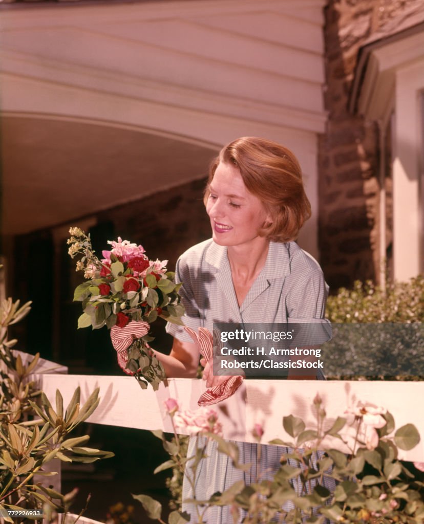 1960s WOMAN HOLDING SMALL...