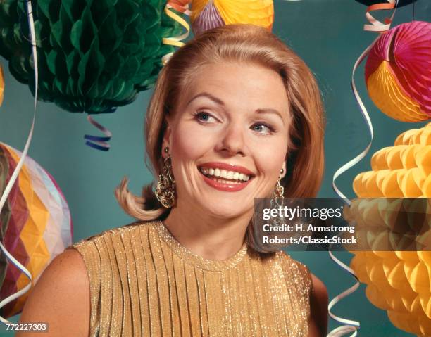 1960s SMILING BLONDE WOMAN WEARING EVENING CLOTHES GOLD LAME BLOUSE AMONG PARTY BALLOONS AND STREAMERS