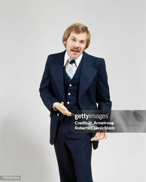 1970s UPSET BUSINESSMAN SHOWING EMPTY POCKETS WEARING A SUIT HAS A MUSTACHE LOOKING AT CAMERA