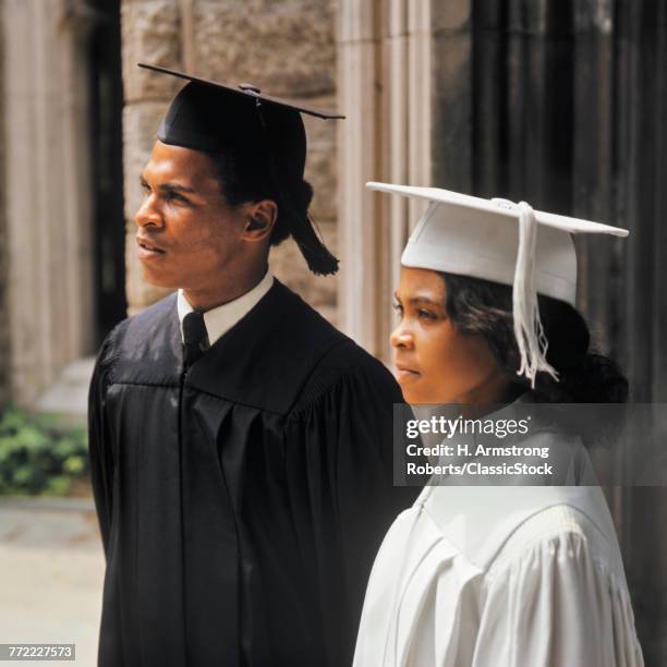 1970s AFRICAN AMERICAN COUPLE WEARING GRADUATION ROBES PORTRAIT