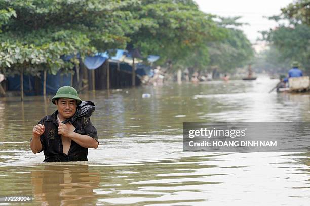 Man walks through a flooded street in Thach Thanh district, in the central province of Thanh Hoa, 08 October 2007. At least 58 people have died in...