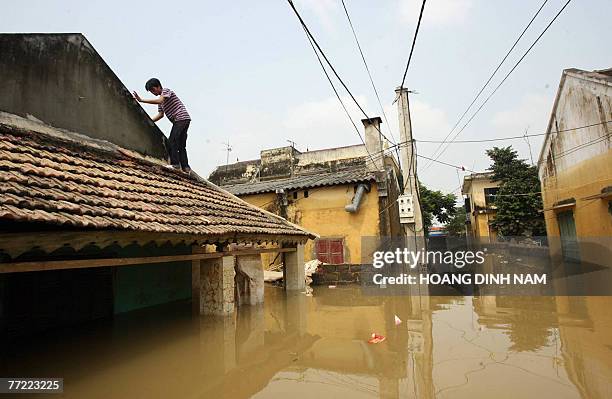 Man walks on a roof of a flooded house in Thach Thanh district, in the central province of Thanh Hoa, 08 October 2007. At least 58 people have died...