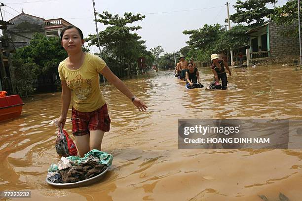 People are seen walking in a flooded street in Thach Thanh district, in the central province of Thanh Hoa, 08 October 2007. At least 58 people have...