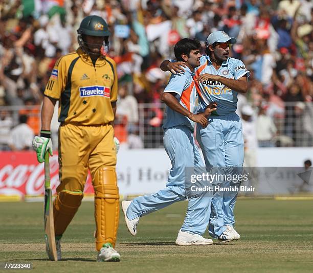 Singh of India is congratulated by team mate Robin Uthappa on the wicket of Adam Gilchrist of Australia during the fourth one day international match...