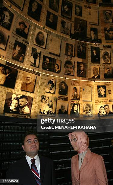 Turkish Foreign Minister Ali Babacan and his wife Zeyneb look at photographs of Jews exterminated in the Holocaust during World War II as he visits...