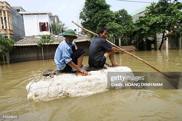 Two men paddles a makeshift raft on a flooded street in Thach Thanh district, in the central province of Thanh Hoa, 08 October 2007. At least 58...