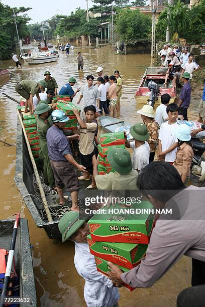 Rescuers load boxes of instant-noodles into a boat to deliver them to people stuck in flooded areas in Thach Thanh district, in the central province...