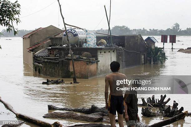 Man stands looking at flooded houses on the banks of the Ma river in the central province of Thanh Hoa, 05 October 2007, after Typhoon Lekima hit the...