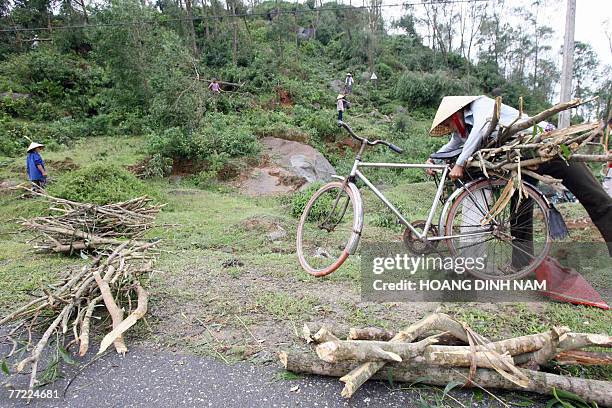 Woman loads wood for cooking on her bicycle after tropical storm Lekima passed in the poor central province of Ha Tinh, 04 October 2007. Typhoon...
