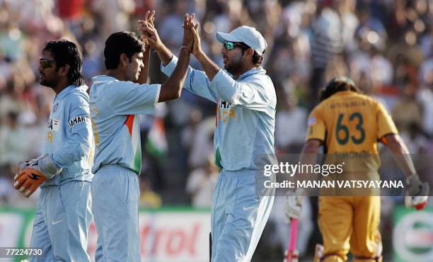 Indian cricketer Yuvraj Singh congratulates teammate Rudra Pratap Singh for taking the wicket of Australian Andrew Symonds during the fourth One-Day...