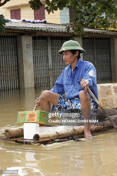Man paddles a makeshift raft on a flooded street in Thach Thanh district, in the central province of Thanh Hoa, 08 October 2007. At least 58 people...