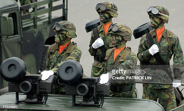 Taiwanese soldiers stand atop military vehicles armed with US-made Javelin anti-tank missiles roar through Taipei's presidential office square during...