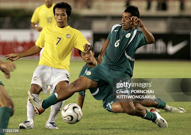Thai football player, Datsakorn Thonglao battle forthe ball with Libano Noruega Emmanuel of Macau during the the 2010 World Cup football qualifier...