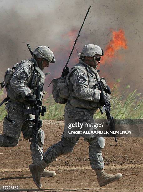 Soldiers from Alpha Company, 1/38 Infantry Regiment move past a fire set to clear undergrowth during a clearing operation outside Baquba, 08 October...