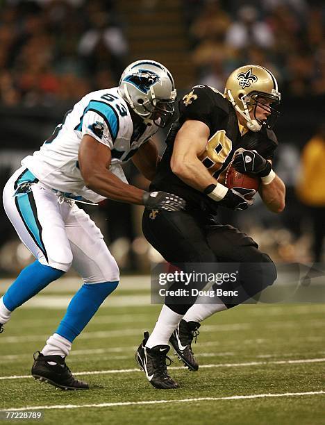 Linebacker Na'il Diggs of the Carolina Panthers brings down tight end Eric Johnson of the New Orleans Saints at the Superdome on October 7, 2007 in...