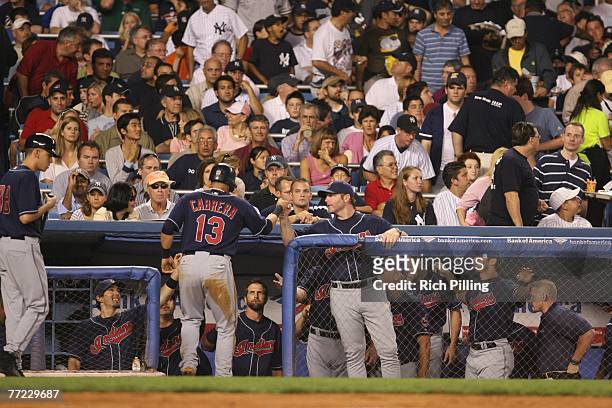 Eric Wedge, manager, congratulates Asdrubal Cabrera of the Cleveland Indians after the Indians scored a run during the American League Division...