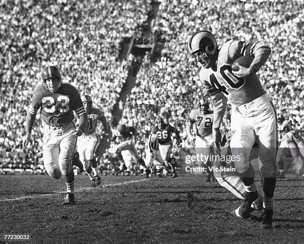 Hall of Fame wide receiver Elroy "Crazylegs" Hirsch of the Los Angeles Rams avoids a tackler as Hardy Brown of the San Francisco 49ers give chase in...