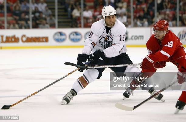 Jarrett Stoll of the Edmonton Oilers tries to get around the stick of Jiri Hudler of the Detroit Red Wings on October 8, 2007 at Joe Louis Arena in...