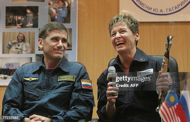 Members of an International space crew Yury Malenchenko of Russia and Peggy Whitson of the United States give after a news conference at Baikonur...