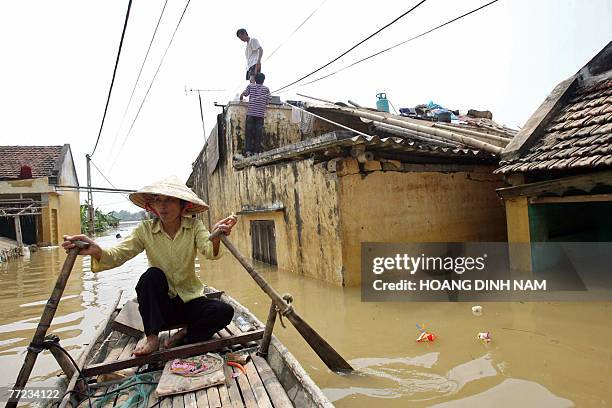 Woman paddles a raft on a flooded street in Thach Thanh district, in the central province of Thanh Hoa, 08 October 2007. At least 58 people have died...