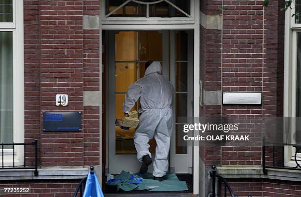 Police investigator arrives 09 October 2007 at the house in Amsterdam of a man who had testified last week in the trial of a local mobster convicted...