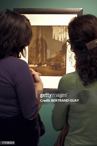 Visitors look at a photograph during an exhibition dedicated to US fashion photographer, war reporter and portraitist Edward Steichen at the Jeu de...