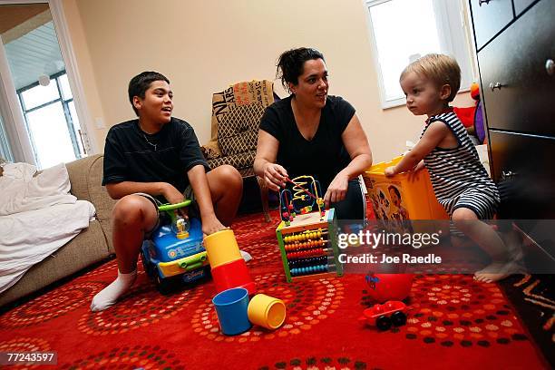 Diane Goldsborough plays with her son's Klaus Goldsborough and John Goldsborough, Jr., in the living room of the home they have lived in for the last...