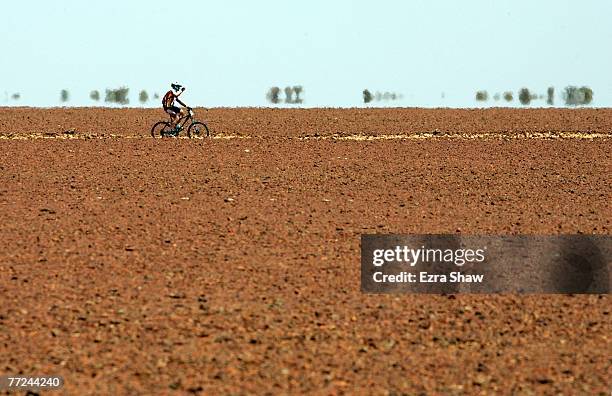 Mathew Dickerson from Dubbo, New South Wales takes a drink of water as he rides across a field of gibber rocks during day four of the Simpson Desert...