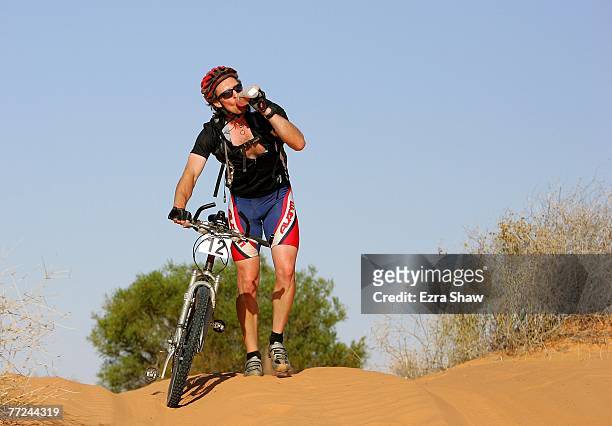 Ryan Hyde of Varley, Western Australia takes a break to take a drink during day two of the Simpson Desert Bike Challenge race on October 3, 2007 in...
