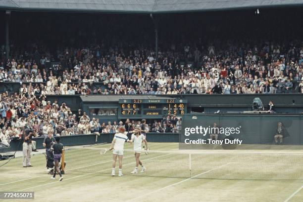 John McEnroe of the United States reaches over the net to shake hands with Bjorn Borg after defeating him during the Men's Singles Final match at the...