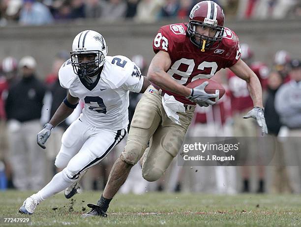 Harvard's Brian Edwards, right, runs by Yale's Fred Kelksduring the Harvard-Yale football game, famously known as "The Game," at Harvard Stadium in...