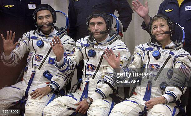 Members of International space crew, Sheikh Muszaphar Shukor of Malaysia, Yury Malenchenko of Russia and US Peggy Whitson wave during a farewell...