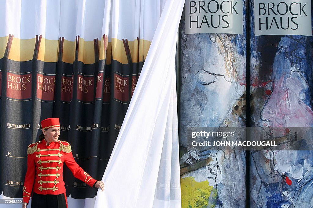 A woman unveils a new edition, illustrat