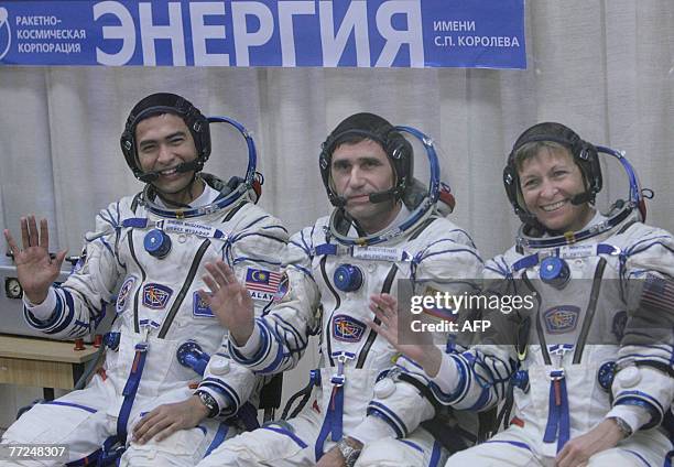 Members of an international space crew Sheikh Muszaphar Shukor of Malaysia, Yury Malenchenko of Russia and US Peggy Whitson wave during a farewell...
