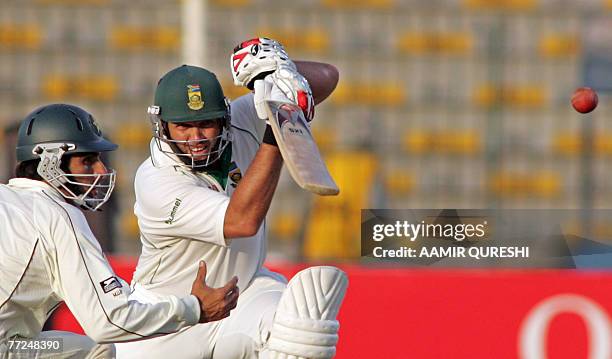 South African cricketer Jacques Kallis play a stroke as Pakistani fielder Misbah-ul-Haq looks on during the third day of the second Test match...