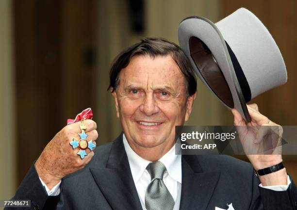 Dr Barry Humphries poses for pictures after he received his Most Excellent Order of the British Empire from the Queen at Buckingham Palace, in...